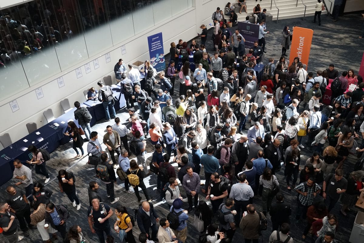 A photo of a large group of people inside a mass networking event, with hundreds of attendees