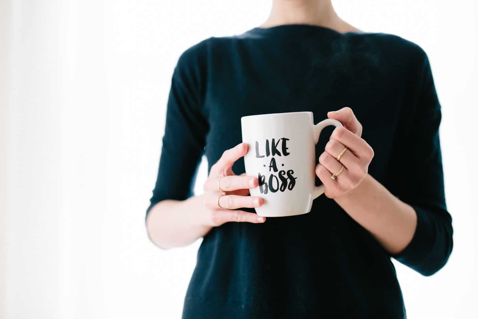 Photo of woman holding a coffee mug that writes like a boss