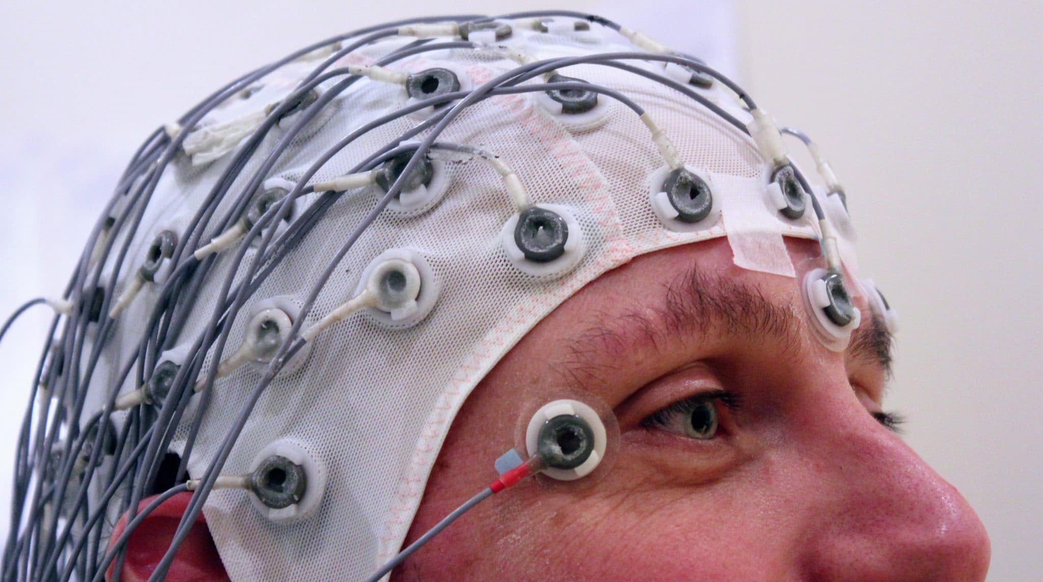 Psychology test, picture of a man with a brainwave measurement device on his head for a test.