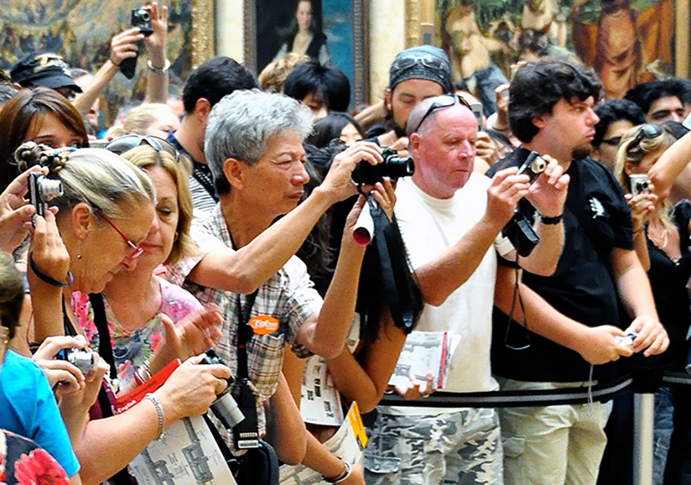 Photo of Big Group of People taking photos of the Mona Lisa. Image related to article on 4 Ways to Improve User Experience and Increase Engagement.