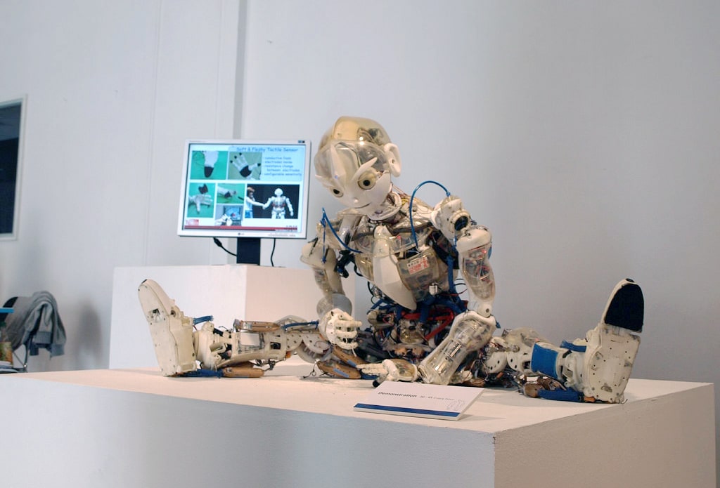 Photo of an artificial intelligence humanoid robot sitting on a desk under develeopment.