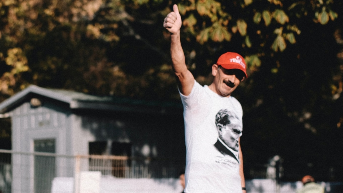 Photo of a Turkish man wearing a t-shirt with Ataturk printed on it as he gives a thumbs up to the camera