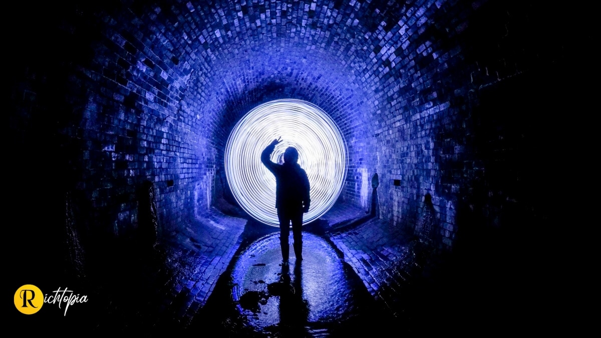 Photo of a man in a tunnel holding the peace sign with his fingers