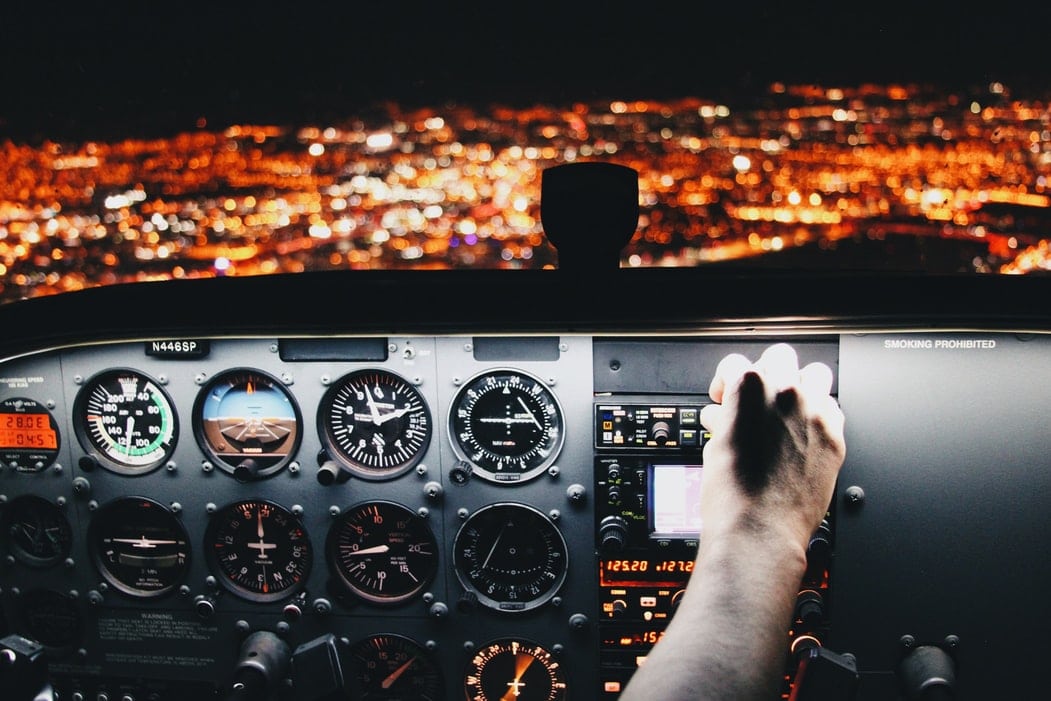 A pilot's hands as he flies a plane of people