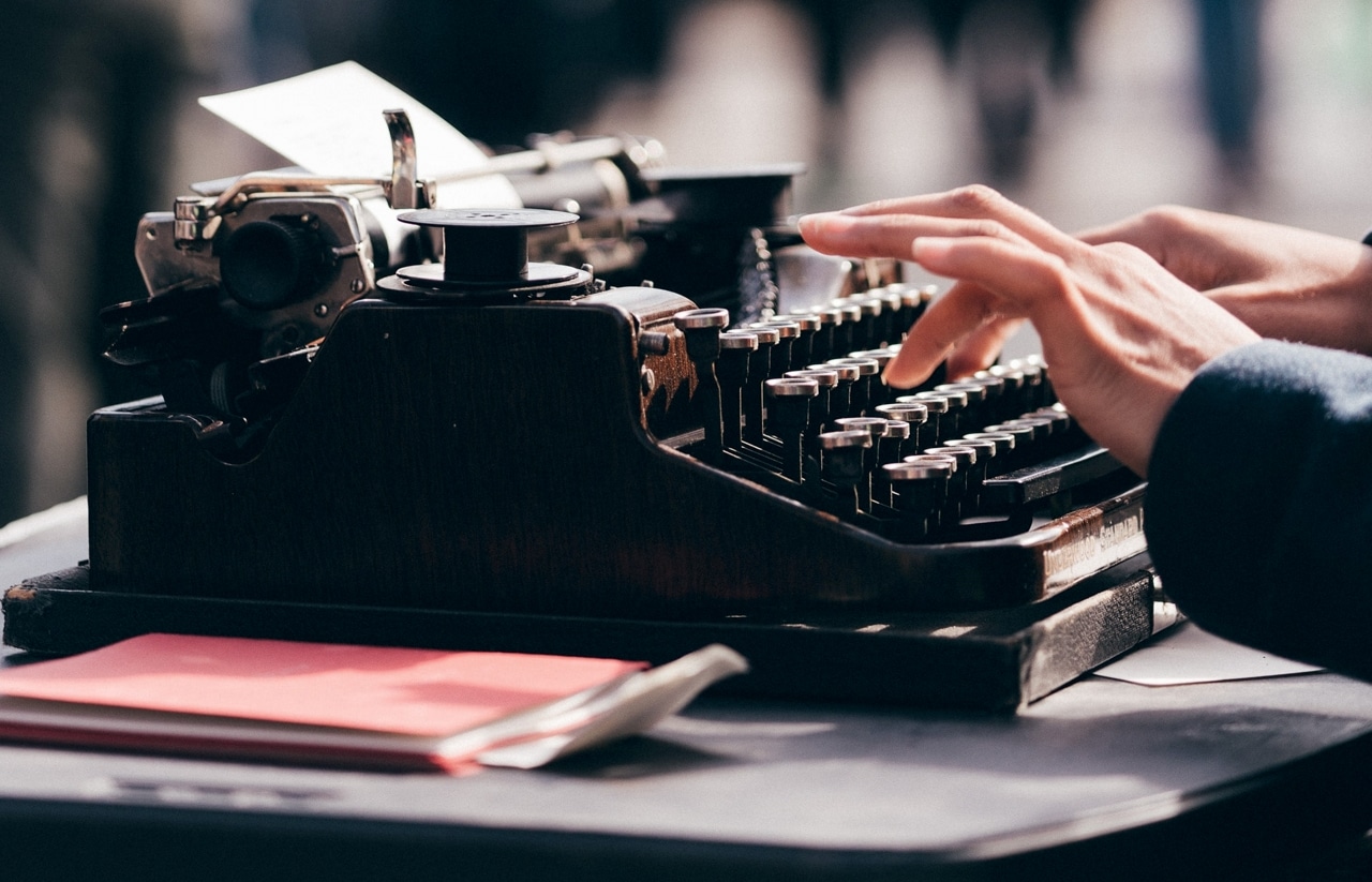 Photo of someone's fingers as they type on a traditional typewriter.