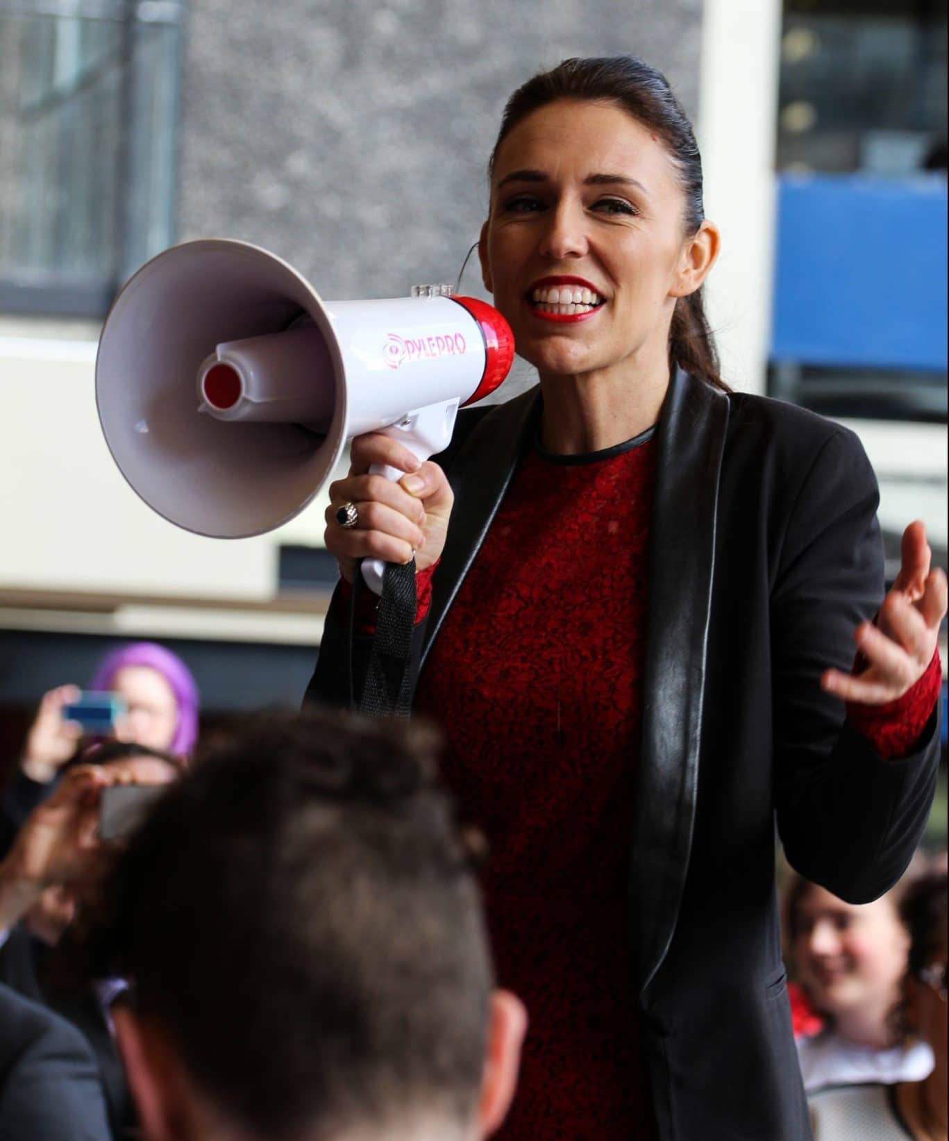 Jacinda Ardern speaking to a crowd of people using a megaphone