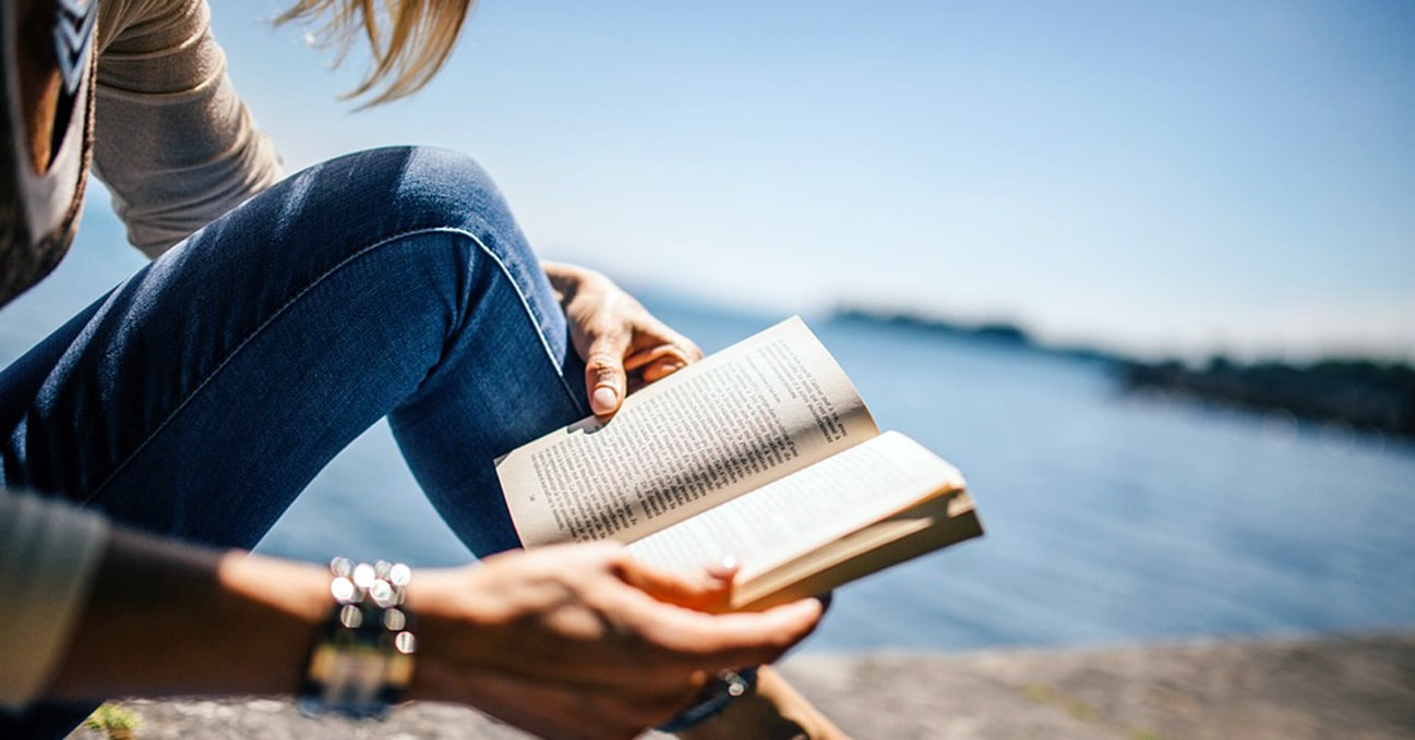 Woman reading a business book during her lunch break at the seaside