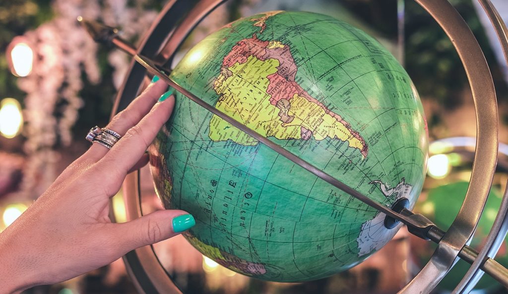 Photo of a woman holding the globe in her fingertips