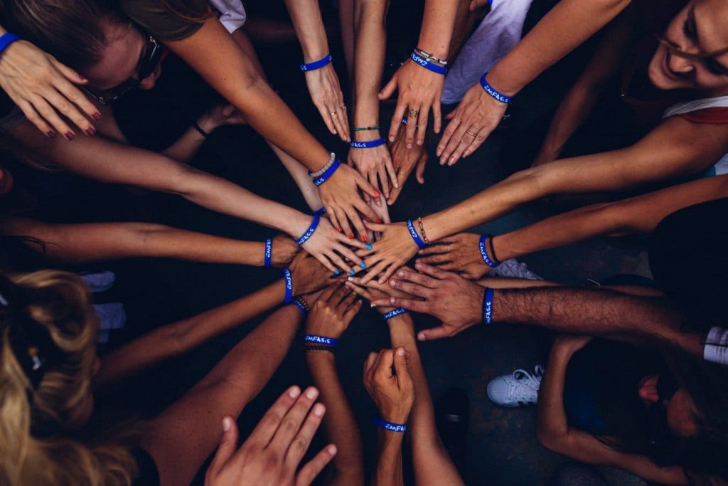 Group of people huddling demonstrating unity and working together