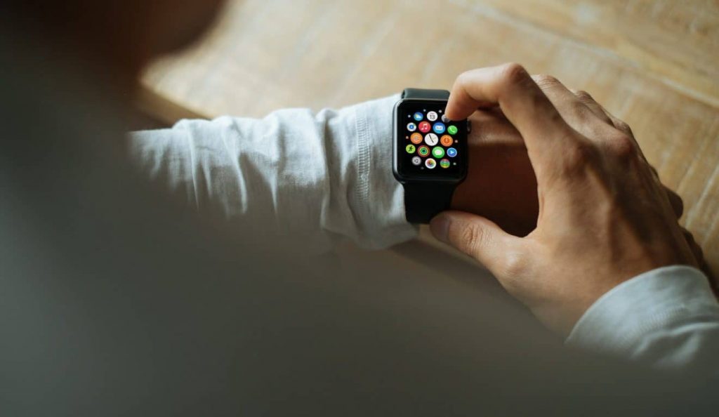 Photo of a man using his black Apple smart-watch
