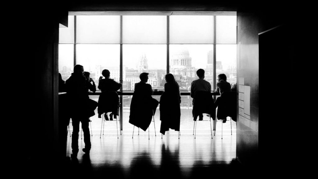 People sitting on chairs in a office environment depicting the corporate world