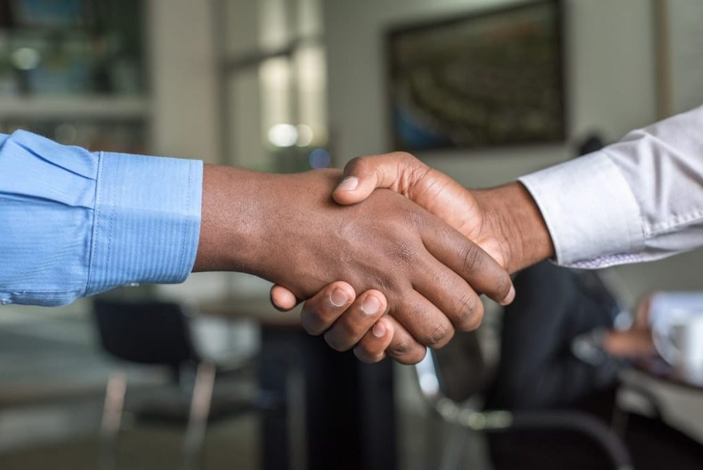 Two men shaking hands depicting private public partnerships