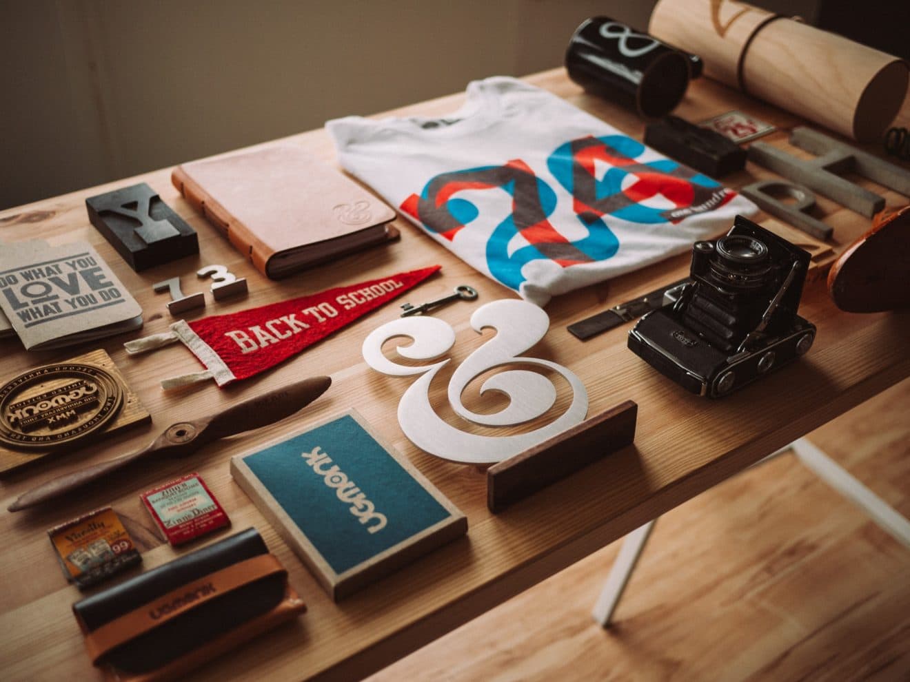 A photography companies assets laid on a table including a banner, an antique camera, and more.
