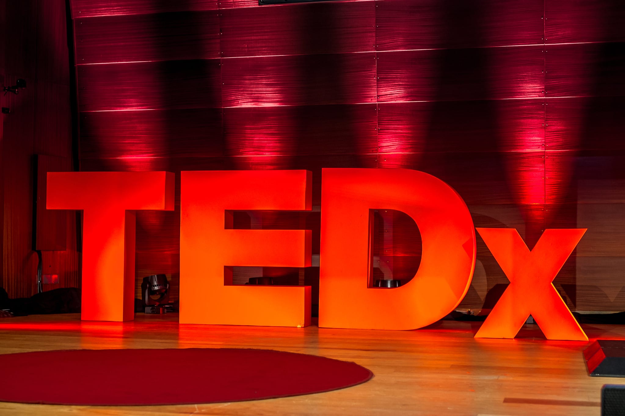 Photo of the TEDx logo background on a stage.