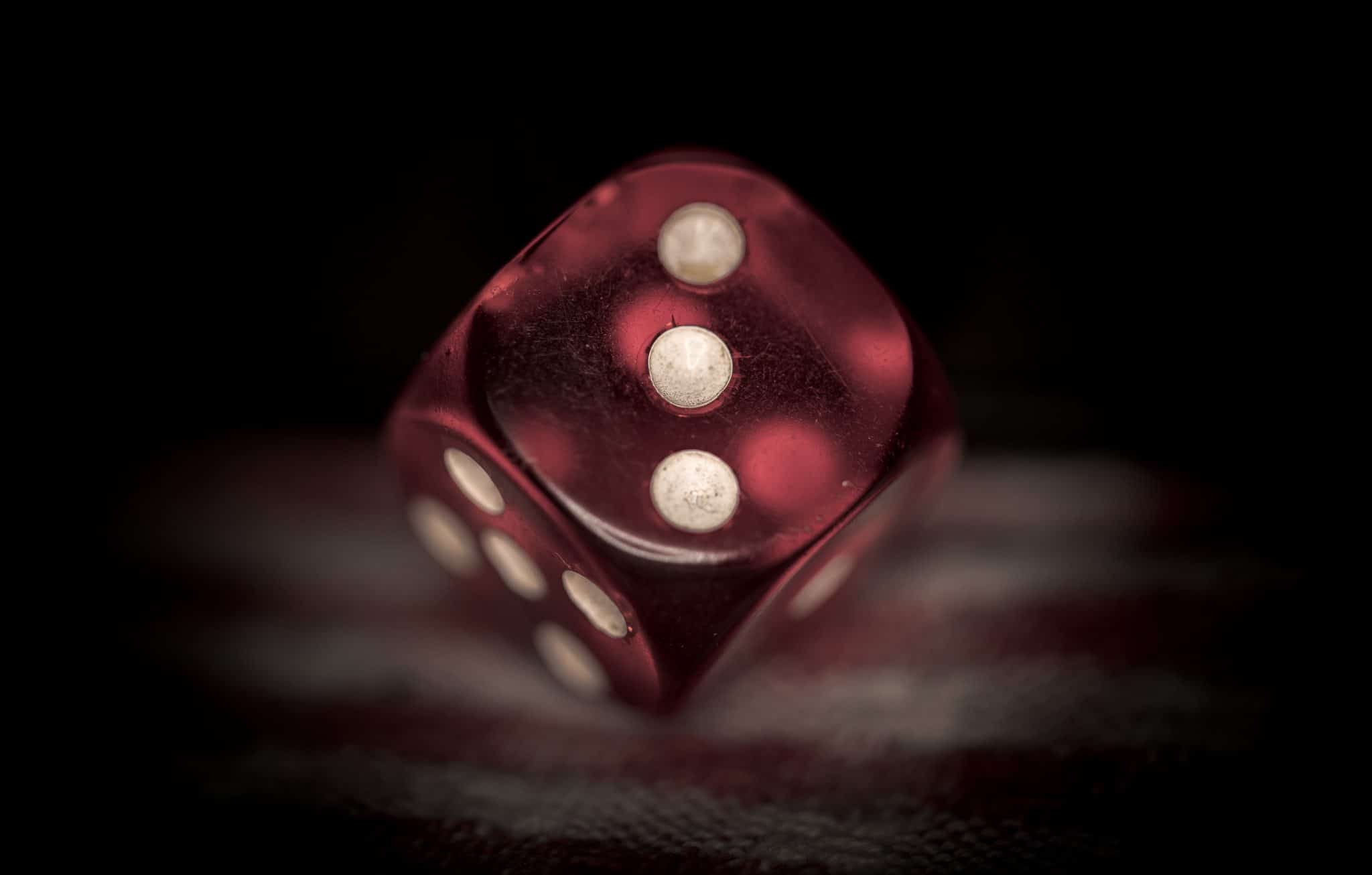 A red dice, showing the number three.