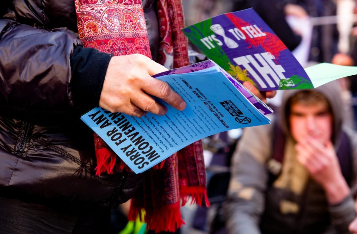 Photo of a woman's hands holding a mix of flyers.