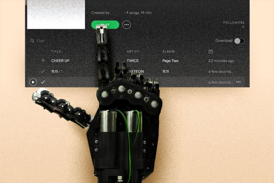 Robotic hand using an index finger to pick songs on a Spotify playlist