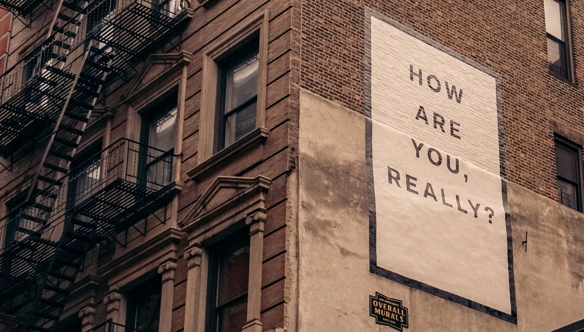 Mural on apartment wall writing 'how are you really?'