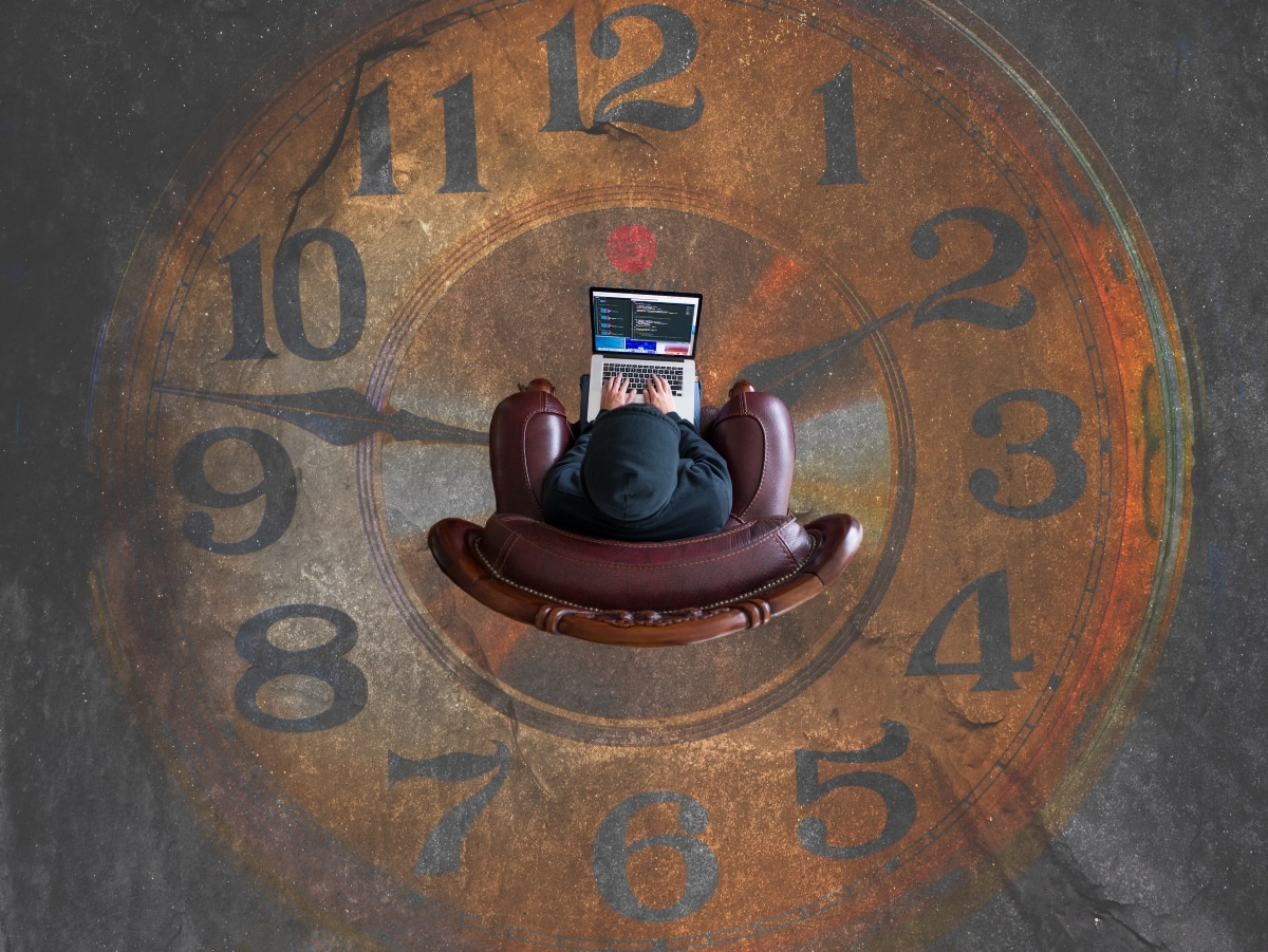 Sitting on a chair whilst using a laptop on top of clock painting on floor