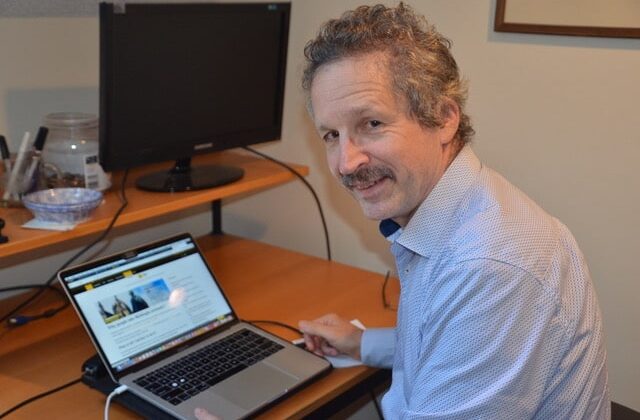 Photo of Jim Estill reading Richtopia on his laptop.